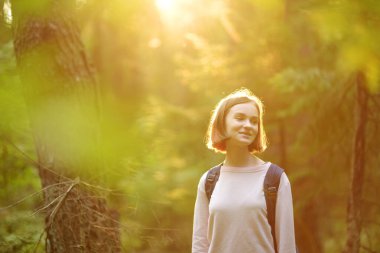 Güzel bir yaz günü, orman yürüyüşü sırasında eğlenen tatlı bir genç kız. Doğayı keşfeden çocuk. Çocuklarla aktif aile eğlencesi.