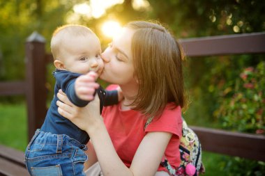 Küçük erkek kardeşine hayran sevimli bir abla. Sevimli genç kız yeni erkek kardeşini kucağında tutuyor. Geniş yaş farkı olan çocuklar. Kardeşler arasında büyük yaş farkı var. Büyük aile..