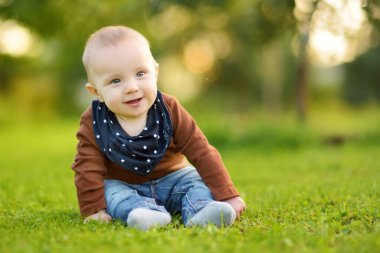 Sevimli beş aylık erkek bebek destek olmadan oturmayı öğreniyor. Döşeme zamanı bebek. Sevimli küçük çocuk tek başına oturmaya çalışıyor..