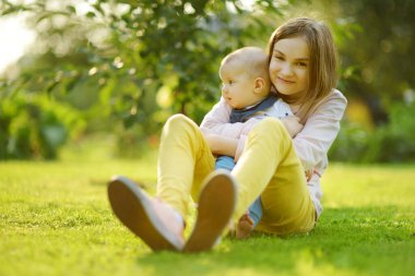 Küçük erkek kardeşine hayran sevimli bir abla. Sevimli genç kız yeni erkek kardeşini kucağında tutuyor. Geniş yaş farkı olan çocuklar. Kardeşler arasında büyük yaş farkı var. Büyük aile..