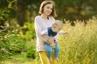 Küçük erkek kardeşine sarılan sevimli bir abla. Sevimli genç kız yeni erkek kardeşini kucağında tutuyor. Geniş yaş farkı olan çocuklar. Kardeşler arasında büyük yaş farkı var. Büyük aile..
