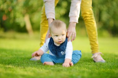 Sevimli beş aylık erkek bebek destek olmadan oturmayı öğreniyor. Döşeme zamanı bebek. Sevimli küçük çocuk tek başına oturmaya çalışıyor..