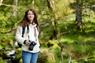 İngiltere 'nin göl bölgesinde bulunan Buttermere Gölü yakınlarındaki ormanlık araziyi keşfeden bir turist, göl boyunca uzanan patikaları sunuyor ve çevredeki dağların zirvelerine yürüyor..