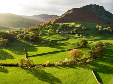 İngiltere 'nin uçsuz bucaksız yemyeşil otlaklarının ve tarım alanlarının havadan görünüşü. Zümrüt yeşili tarlaları ve çayırları olan güzel bir İngiliz kırsalı. Gün batımında kırsal alan.