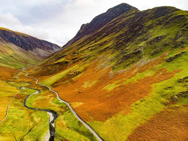 Aerial view of Honister Pass, a mountain pass with a road winding along Gatesgarthdale Beck mountain stream. One of the steepest and highest passes in the region. Cumbria, the Lake District, England.