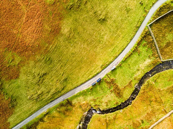 Aerial view of Honister Pass, a mountain pass with a road winding along Gatesgarthdale Beck mountain stream. One of the steepest and highest passes in the region. Cumbria, the Lake District, England.