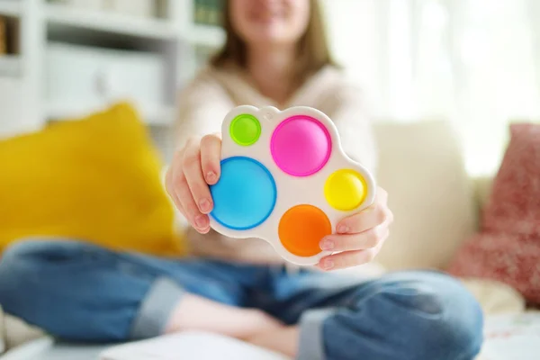 Teenage Girl Playing Rainbow Pop Fidget Toy While Studying Home — Stock Photo, Image