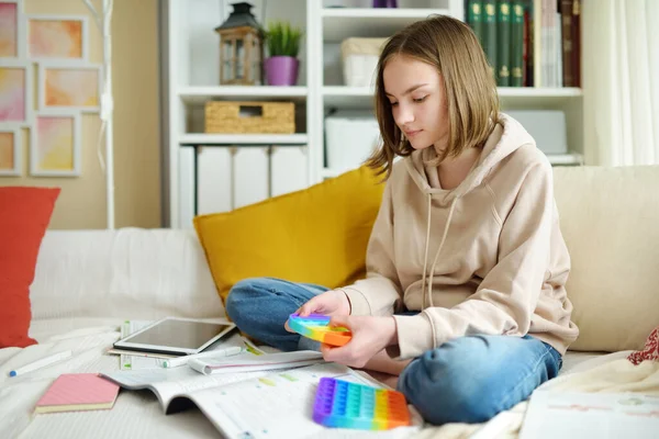 Tonårstjej Leker Med Regnbågens Pop Fidget Leksak När Han Studerar — Stockfoto