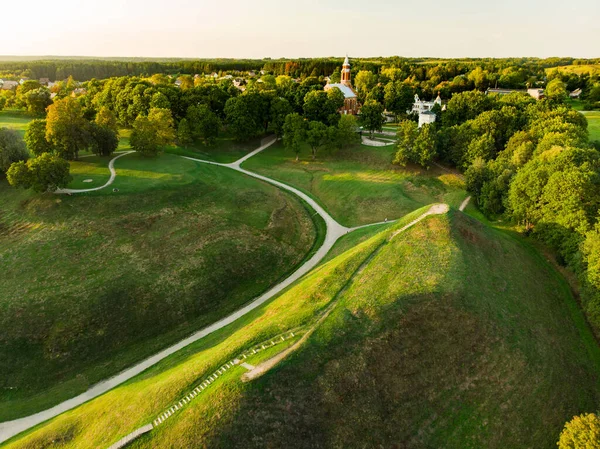 Aerial view of Kernave Archaeological site, a medieval capital of the Grand Duchy of Lithuania, tourist attraction and UNESCO World Heritage Site. Sunny summer evening.