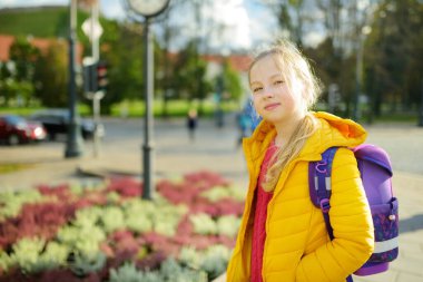 Soğuk bir sonbahar sabahı okula giden sırt çantalı tatlı bir genç kız.