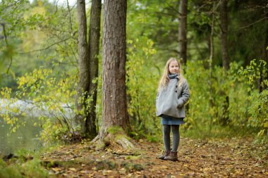Güzel bir sonbahar gününde ormanda eğlenen tatlı bir genç kız. Çocuklarla aktif aile eğlencesi. Aile eğlencesi..