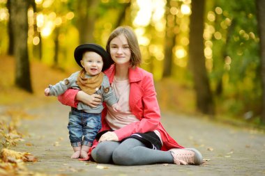 Küçük erkek kardeşine sarılan sevimli bir abla. Sevimli genç kız yeni erkek kardeşini kucağında tutuyor. Geniş yaş farkı olan çocuklar. Kardeşler arasında büyük yaş farkı var. Büyük aile..