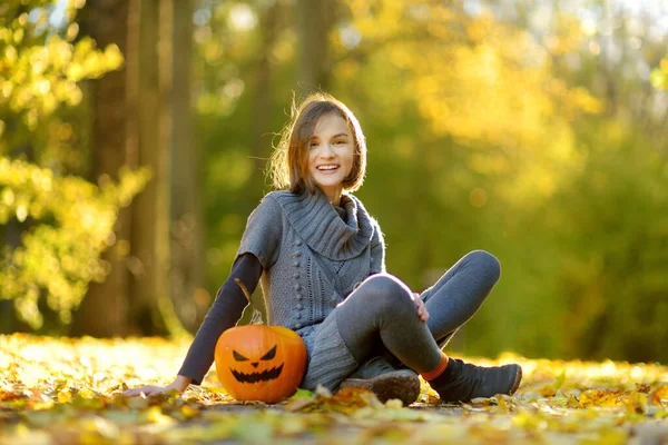 晴れた秋の日に絵に描いたような怖い顔をした小さなカボチャを持つかわいい若い女の子 子供のトリックやハロウィーンの治療 感謝祭とハロウィーンの家族の時間 10月の祭りの季節 — ストック写真
