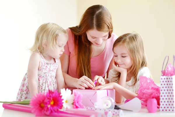 Mother and daughters with gift — Stock Photo, Image