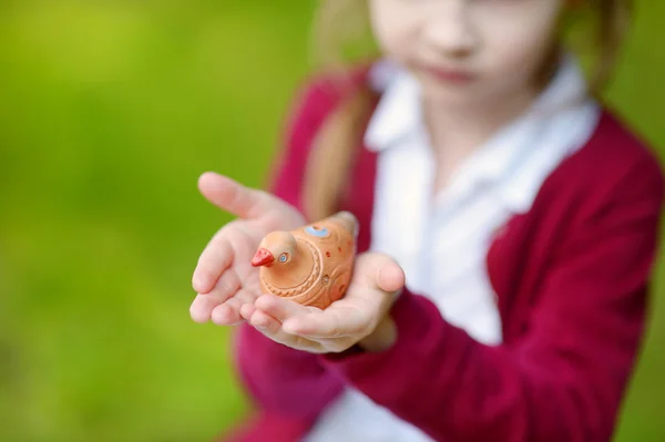 Girl holding clay whistle — Stock Photo, Image