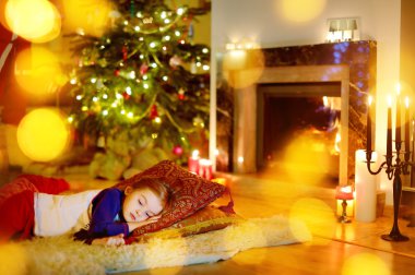 Girl sleeping under Christmas tree clipart