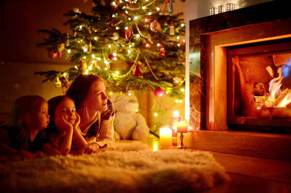 Mother and daughters near fireplace