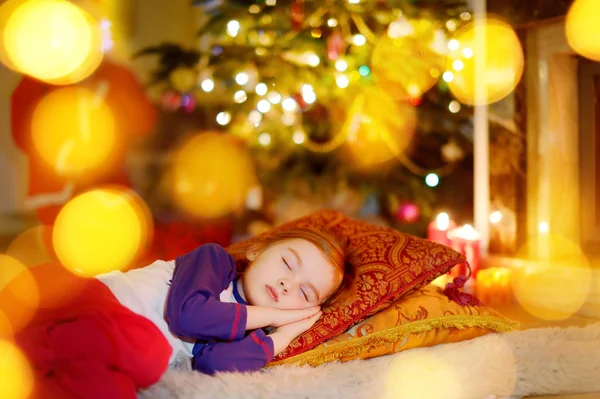 Menina dormindo debaixo da árvore de Natal — Fotografia de Stock