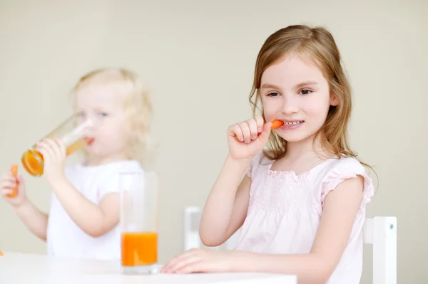 Dos hermanas comiendo zanahorias — Foto de Stock