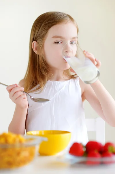 Tjej äter flingor med mjölk — Stockfoto