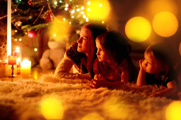 Madre e hijas cerca de la chimenea — Foto de Stock