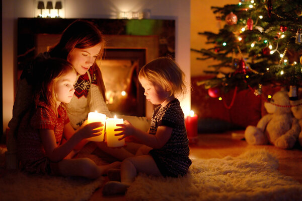 Mother and daughters near fireplace