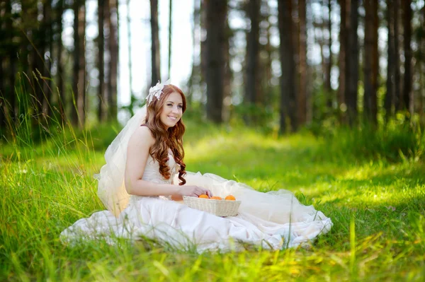 Jonge bruid zittend op een gras — Stockfoto