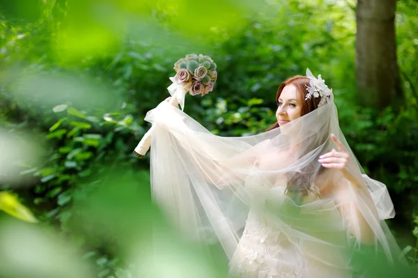 Невеста позирует в красивом летнем парке — стоковое фото