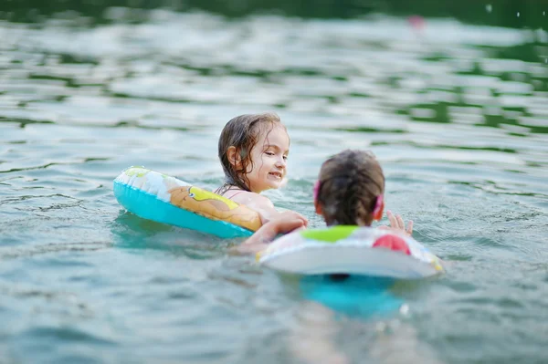 Little sisters swimming in lake — Stock Photo, Image