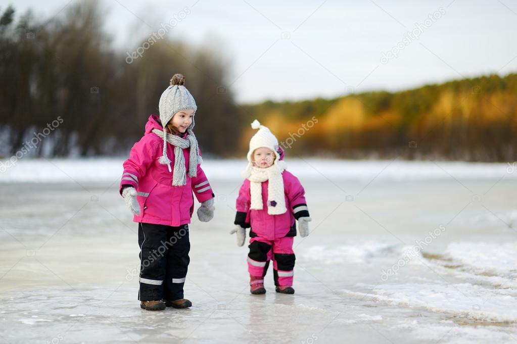 Little sisters on snowy winter day