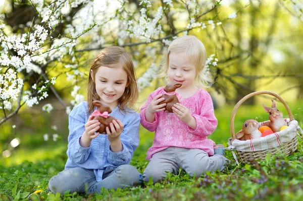 Little sisters eating chocolate bunnies — Stock Photo, Image