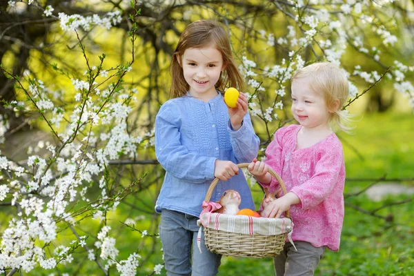 Hermanitas con huevos de Pascua en cesta — Foto de Stock