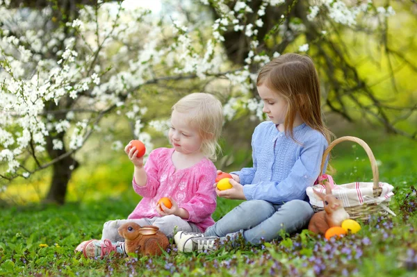 Kleine Schwestern spielen mit Ostereiern — Stockfoto