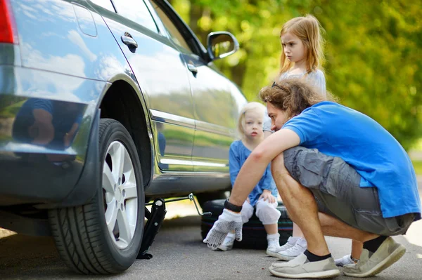 Father and daughters changing car wheel — Stock Photo, Image