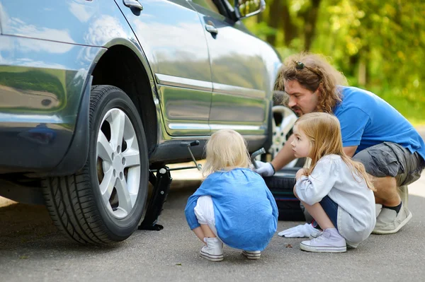 Father and daughters changing car wheel — Stock Photo, Image