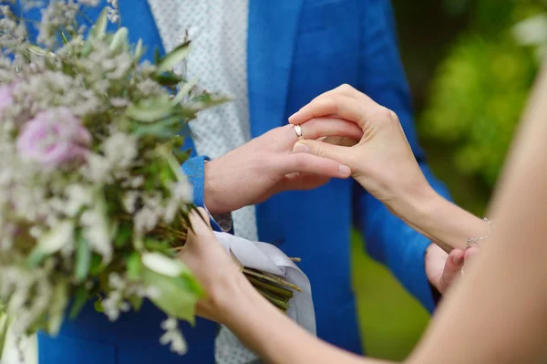 Bride putting wedding ring on groom finger — Stock Photo, Image