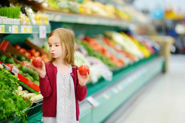 Niña eligiendo tomates — Foto de Stock