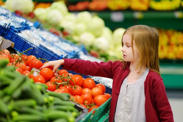 Niña eligiendo tomates — Foto de Stock