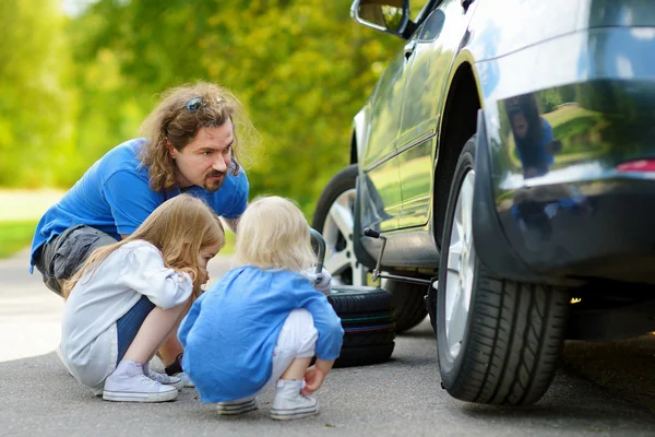 Father and daughters changing car wheel — Stock Photo, Image