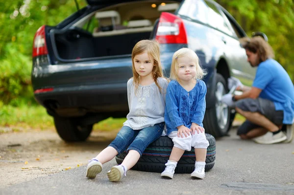 Младшие сестры сидят на колесах — стоковое фото