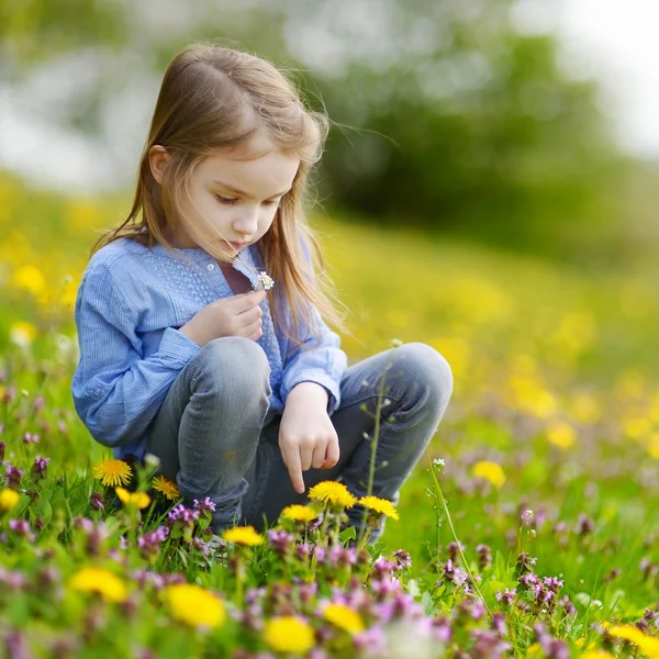 Girl in blooming dandelion flowers — Stock Photo, Image