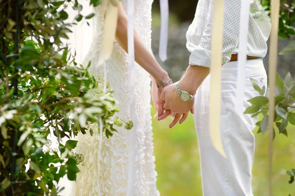 Bride and groom holding hands — Stock Photo, Image