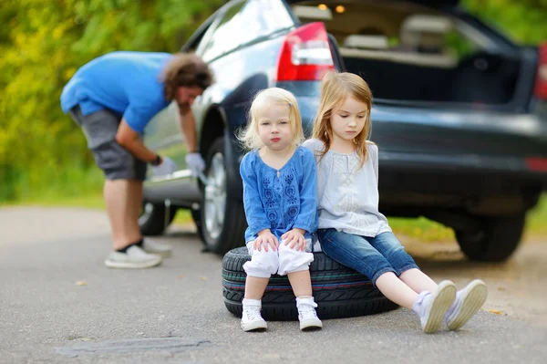 Little sisters sitting on tire — Stock Photo, Image
