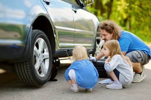 Father and daughters changing car wheel — Stock Photo, Image