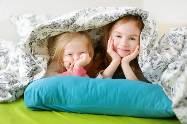 Sisters playing in bed — Stock Photo, Image