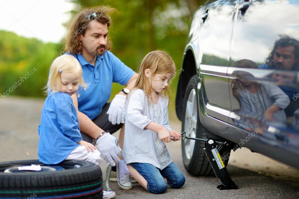Little girl helping father with car