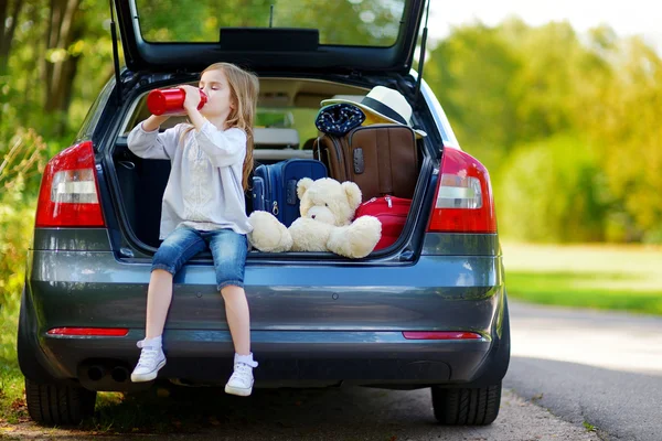 Niña bebiendo agua en el coche — Foto de Stock