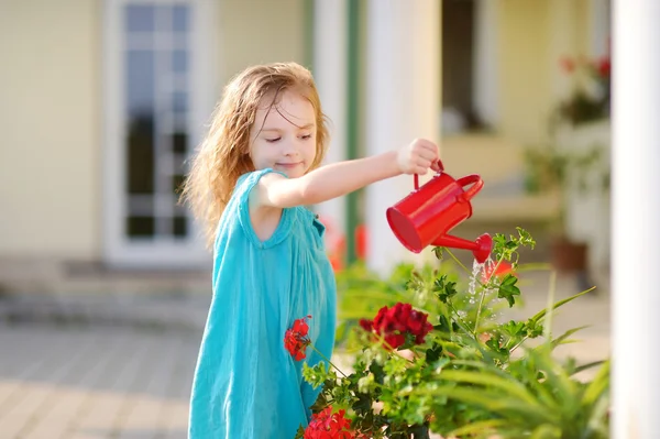 Kleines Mädchen gießt Blumen — Stockfoto