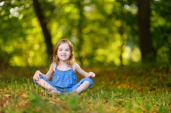 Cute dziewczynka siedzi na trawie — Zdjęcie stockowe