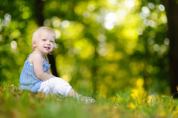 Seltsames Mädchen sitzt auf Gras — Stockfoto